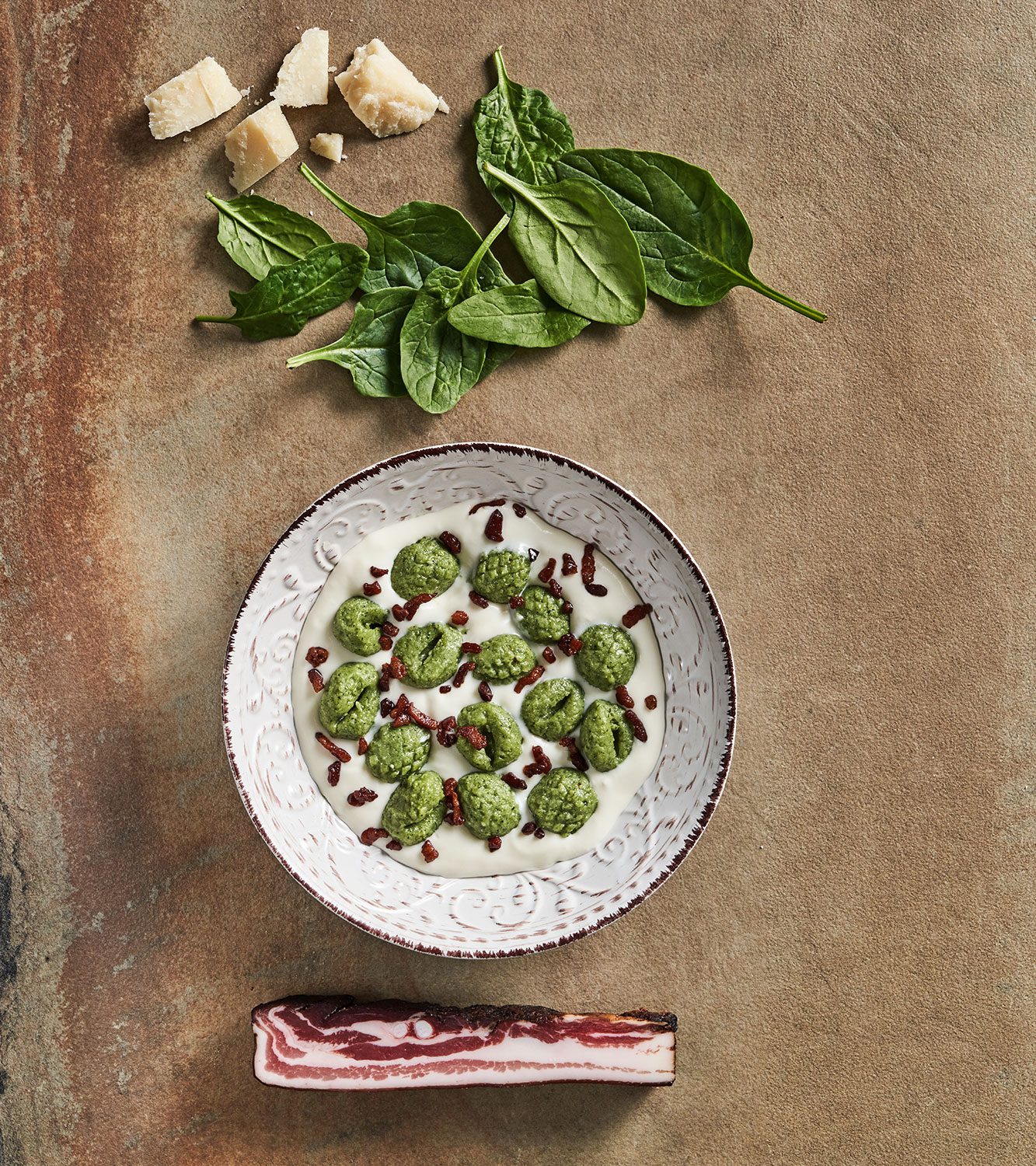 Gnocchi ricotta e spinaci con crema di parmigiano e pancetta croccante