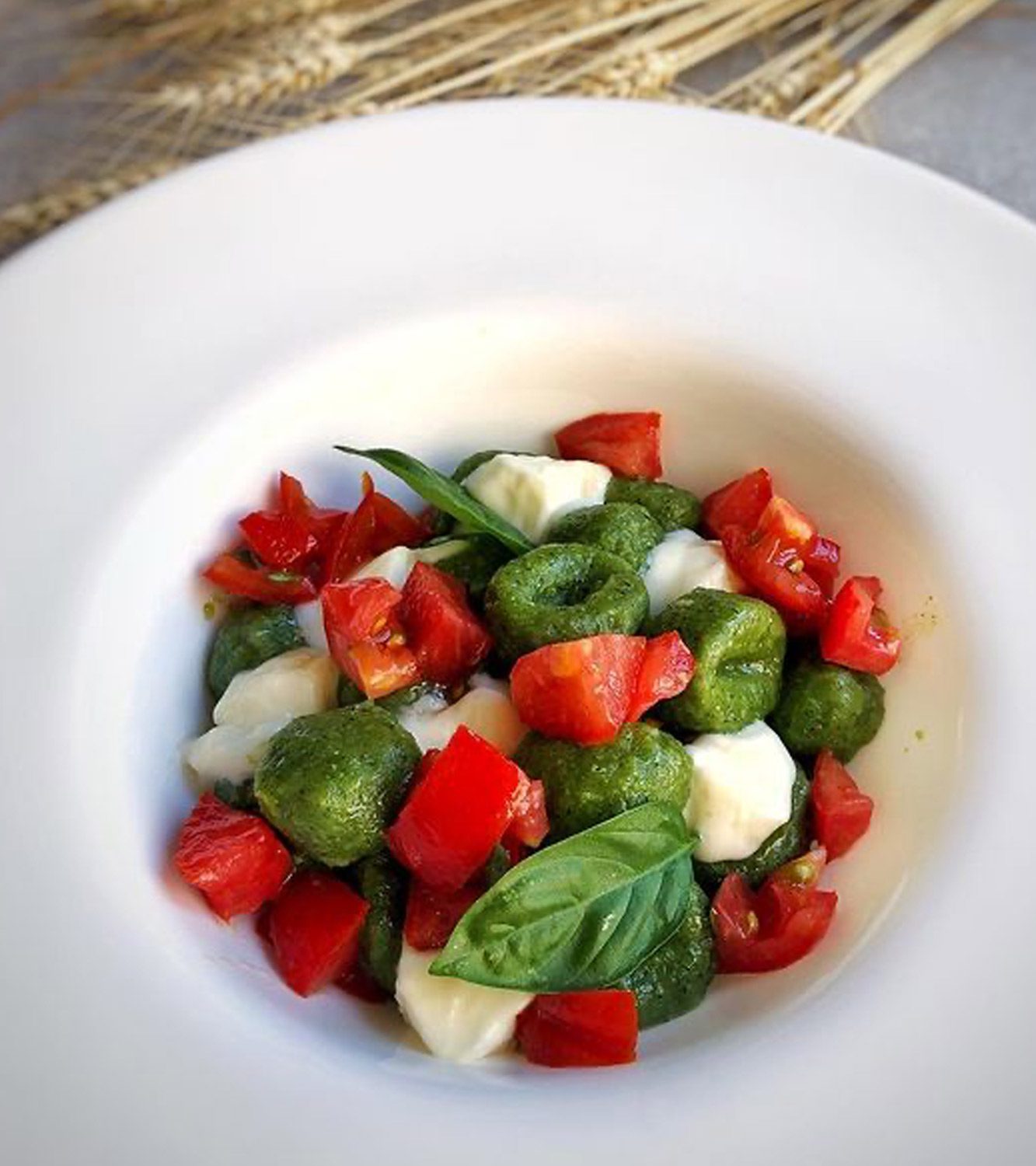 Gnocchi verdi saltati all’olio e basilico con cuore di bue marinato con olio e aglio e casatella fresca